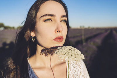 Woman with white flowers day dreaming on sunny day