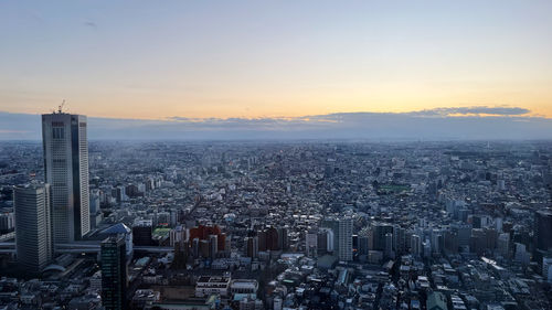 Aerial view of cityscape against sky during sunset