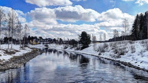 Scenic view of river against cloudy sky