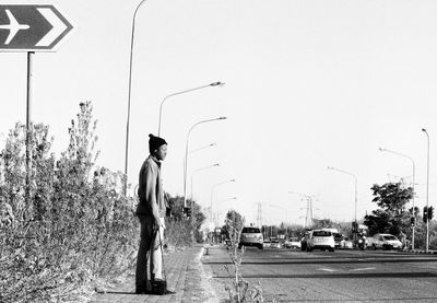 Man standing on road against clear sky
