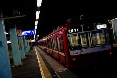 Train at railroad station platform at night