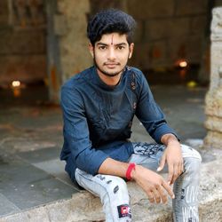 Portrait of young man sitting in city