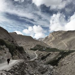 Man standing on mountain against cloudy sky