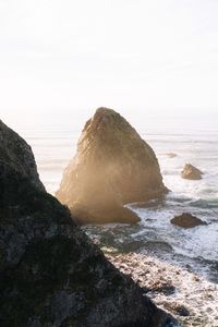 Rock formation on beach against sky