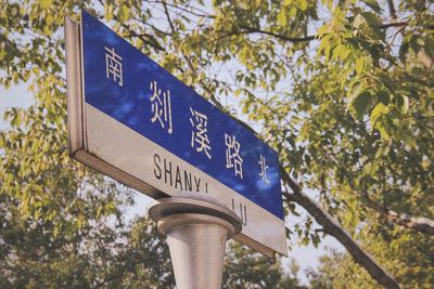 Low angle view of road sign against sky