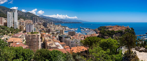 Panoramic shot of city by sea against blue sky