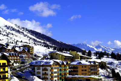 Houses in town against cloudy sky