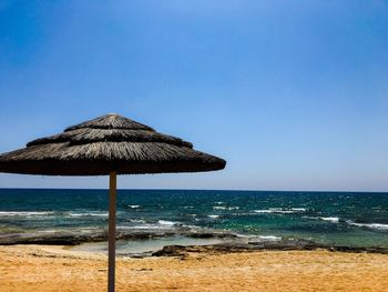 Built structure on beach against clear blue sky