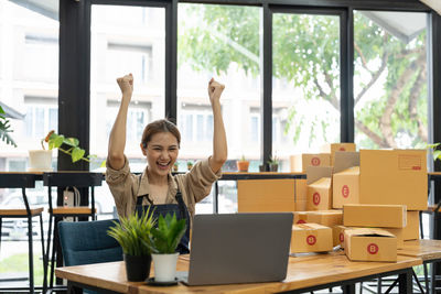 Portrait of smiling woman using mobile phone at office