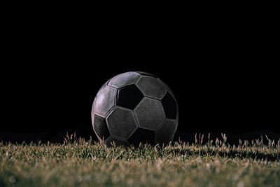 Close-up of ball on field against black background