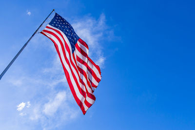 Low angle view of american flag against blue sky