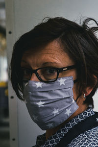 Close-up portrait of woman wearing mask standing indoors