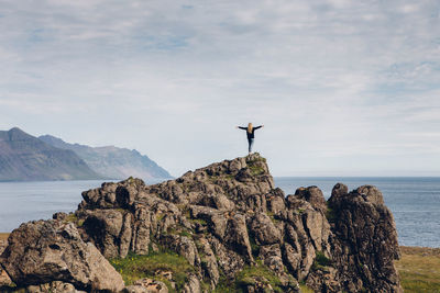 Rear view of woman on rock against sea