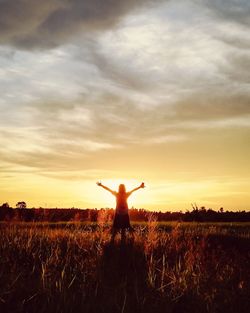 Man standing on field against sky during sunset