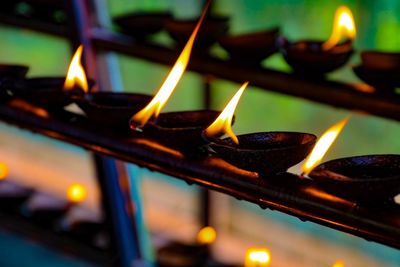 Close-up of lit tea light candles in temple