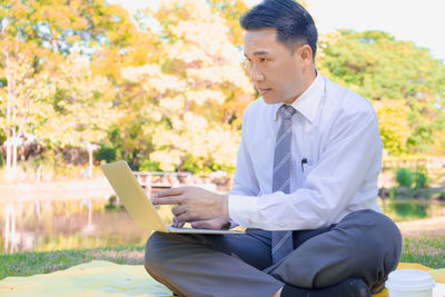 Man looking at camera while sitting on mobile phone