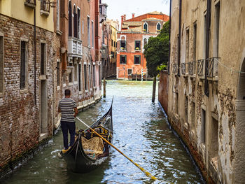 Boats in canal amidst buildings in city