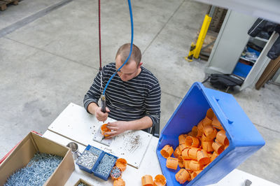 Worker in factory assembling plastic connectors