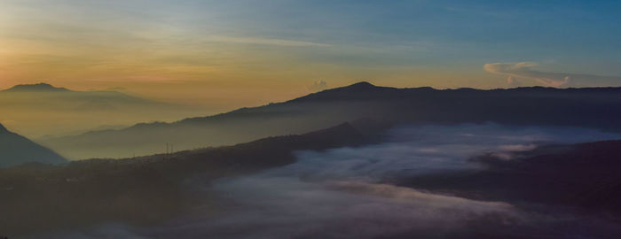 Scenic view of silhouette mountains against sky during sunset