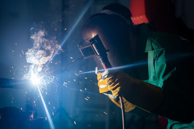 Man working on metal in dark