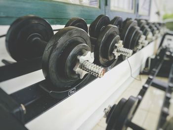 Close-up of dumbbells on shelf at gym