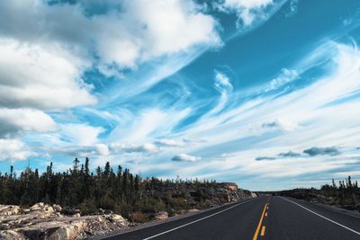 Road amidst trees against sky