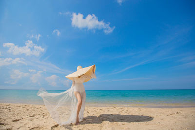 Woman on beach against blue sky