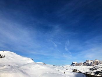 Scenic view of snowcapped mountains against blue sky