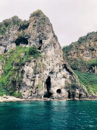 Rock formations by sea against sky