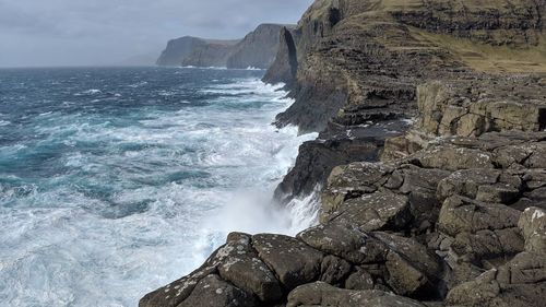 Scenic view of rocks in sea against sky