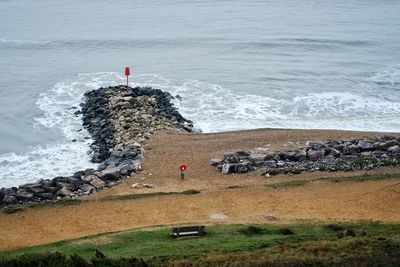 Lighthouse on rocks by sea