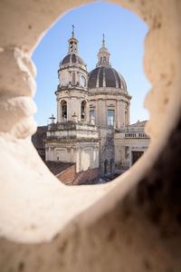 Low angle view of church seen throgh hole against sky