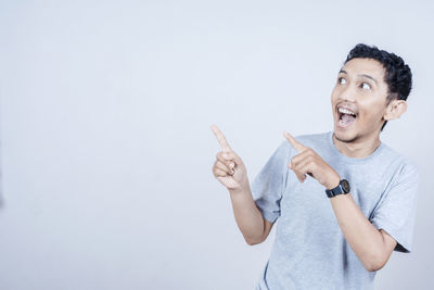 Portrait of smiling man standing against white background