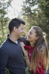 Young couple kissing against plants