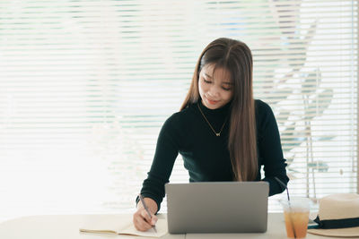 Businesswoman using laptop at home