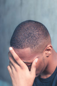 Side view of man holding his head