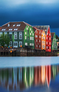 Reflection of building in sea against clear sky