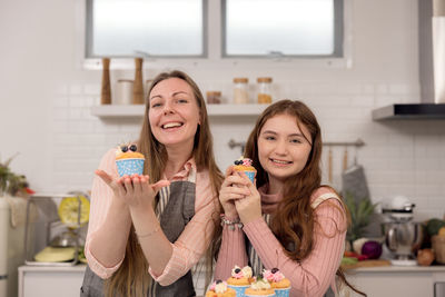 Portrait of smiling woman holding food at home