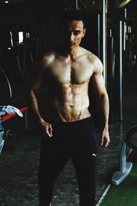 Full length of shirtless man standing in kitchen