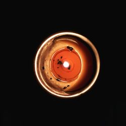 Close-up of illuminated electric lamp over black background