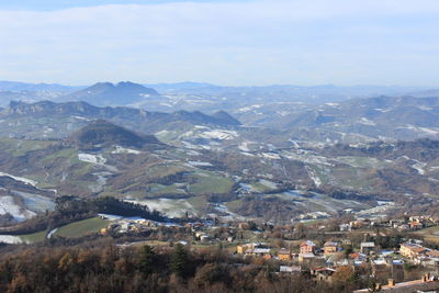 Aerial view of houses and mountains against sky