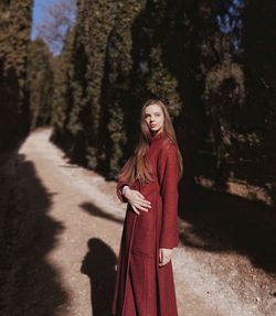 Fashionable woman standing on footpath in forest