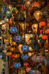 Illuminated lanterns hanging in market for sale