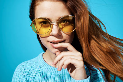 Portrait of beautiful woman against blue background