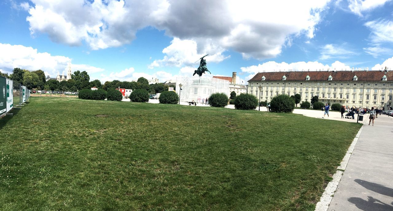 architecture, building exterior, built structure, grass, green color, sky, cloud - sky, tree, city, growth, day, outdoors, grassy, decoration, lawn, person, footpath, grass area