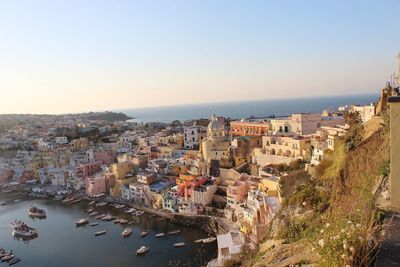 High angle view of townscape by sea against clear sky