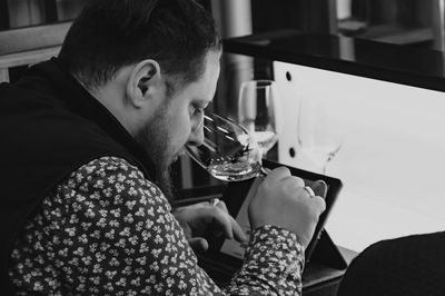 Close-up of man drinking wine in restaurant