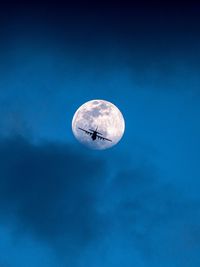 Low angle view of moon against blue sky at night