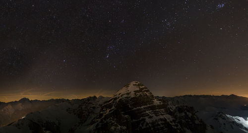 Scenic view of snowcapped mountains against sky at night