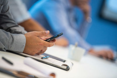 Low angle view of man using mobile phone on table